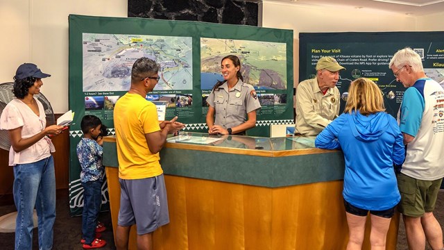 A group of visitors at the Welcome Center talking to a ranger. 