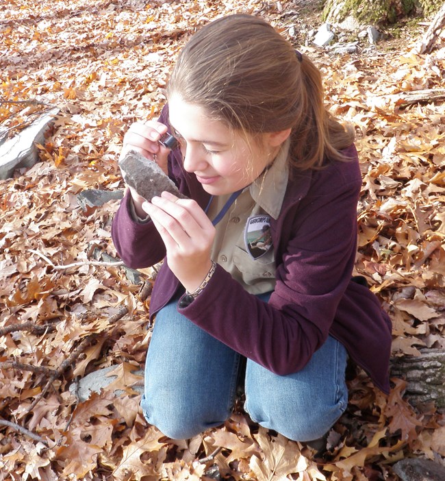 CATO_2010_GIP_Vulgaropulos_Zoe_photo5_crop person with hand lens examining a rock